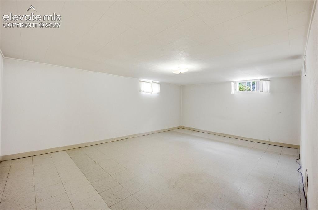 Image 30 of 46: Spacious room featuring light-colored floor tiles, white painted walls, and
