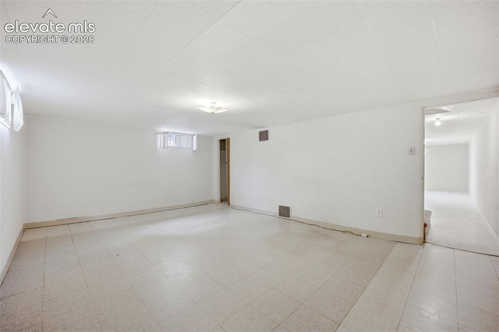 Image 32 of 46: Spacious room featuring light-toned flooring, white walls, and a drop ceili