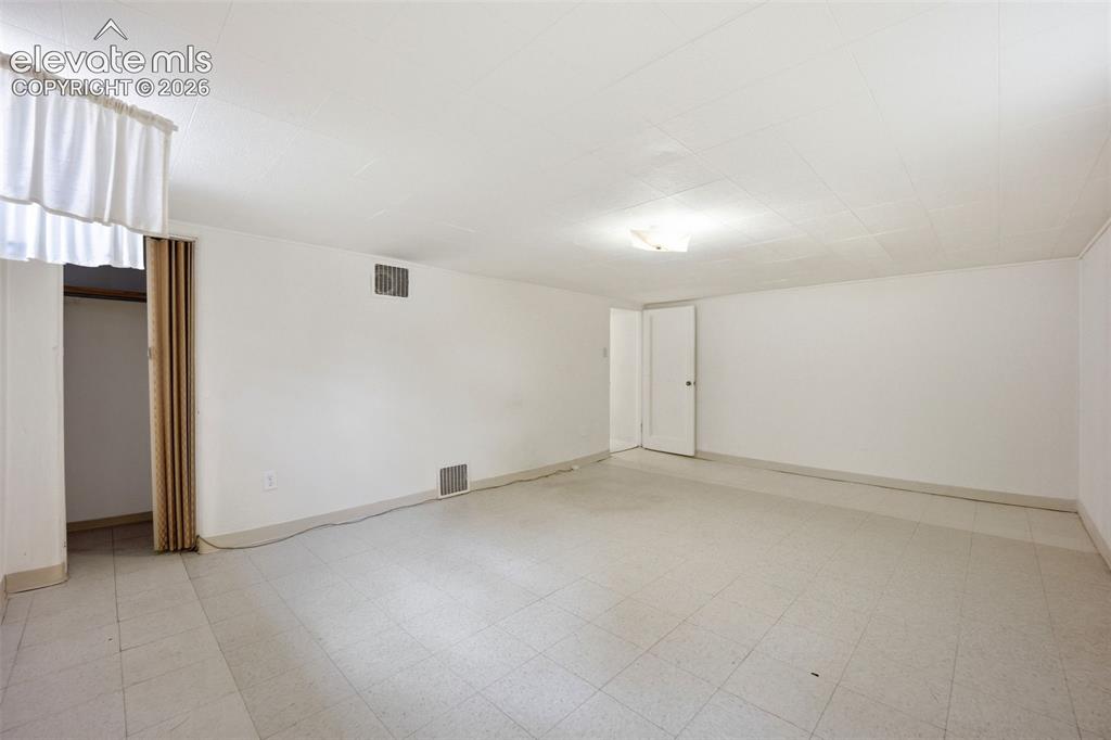 Image 33 of 46: Spacious interior room featuring light-colored tile flooring, white painted