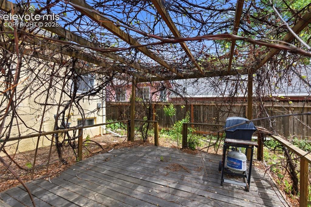 Image 38 of 46: Exterior wood deck with an overhead pergola structure