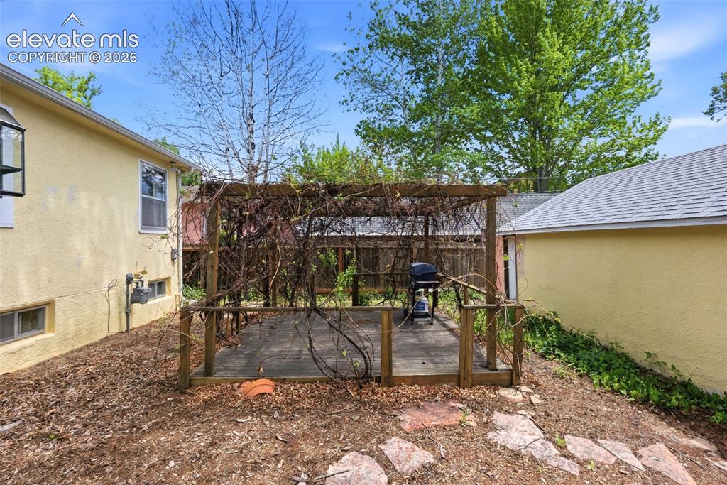 Image 39 of 46: Outdoor deck featuring a wood pergola and flagstone pathway