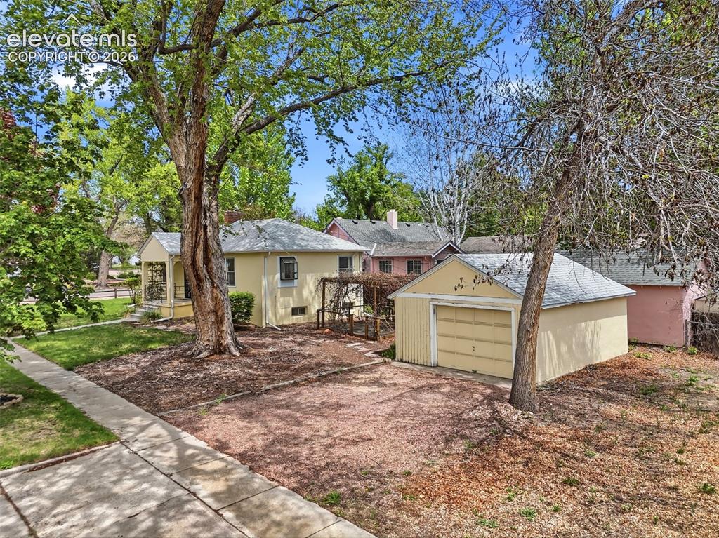 Image 40 of 46: Cream-colored exterior featuring a covered front entry porch, a detached si