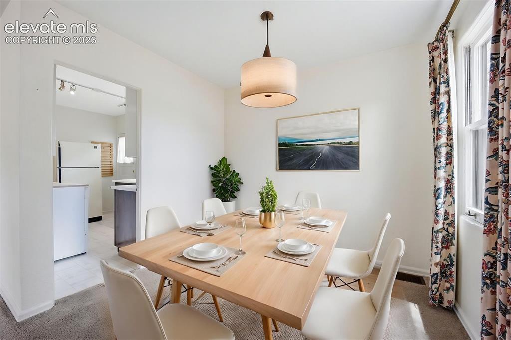 Image 9 of 46: Bright dining area featuring a drum pendant light, white walls, and a windo