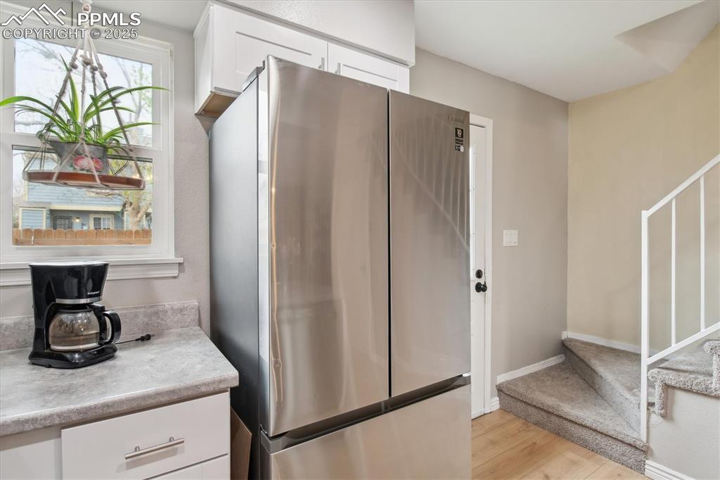 Image 15 of 24: Kitchen with light countertops, baseboards, white cabinets, freestanding re