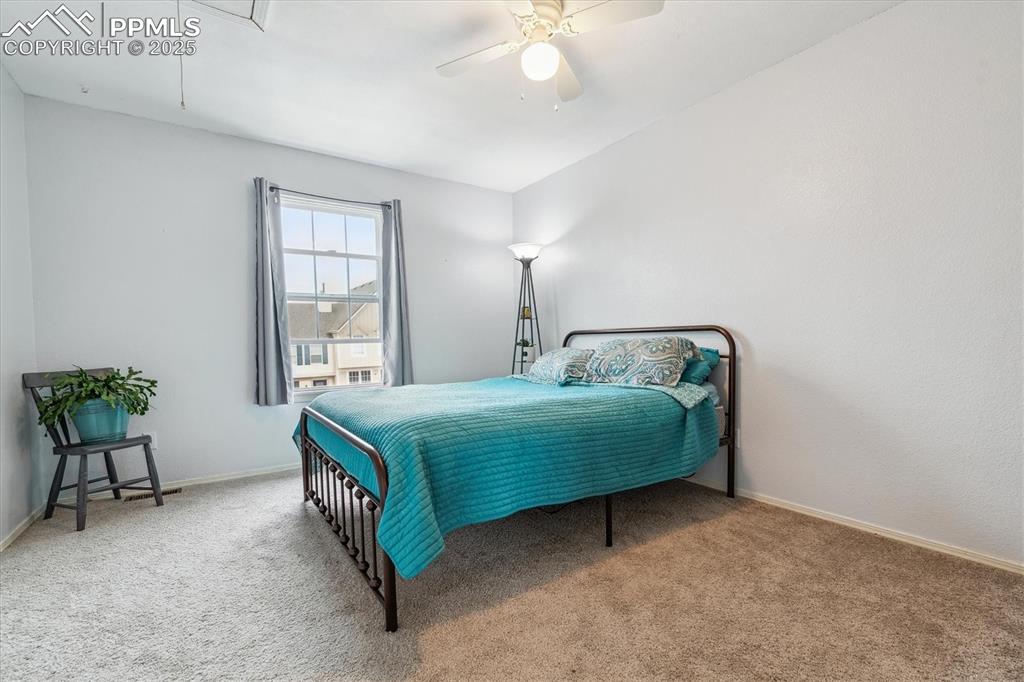 Image 16 of 24: Bedroom featuring baseboards, ceiling fan, attic access, and carpet floorin