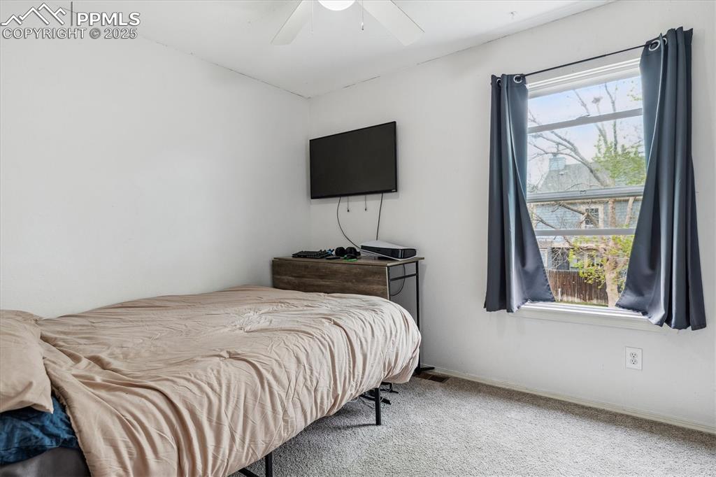 Image 19 of 24: Carpeted bedroom featuring ceiling fan