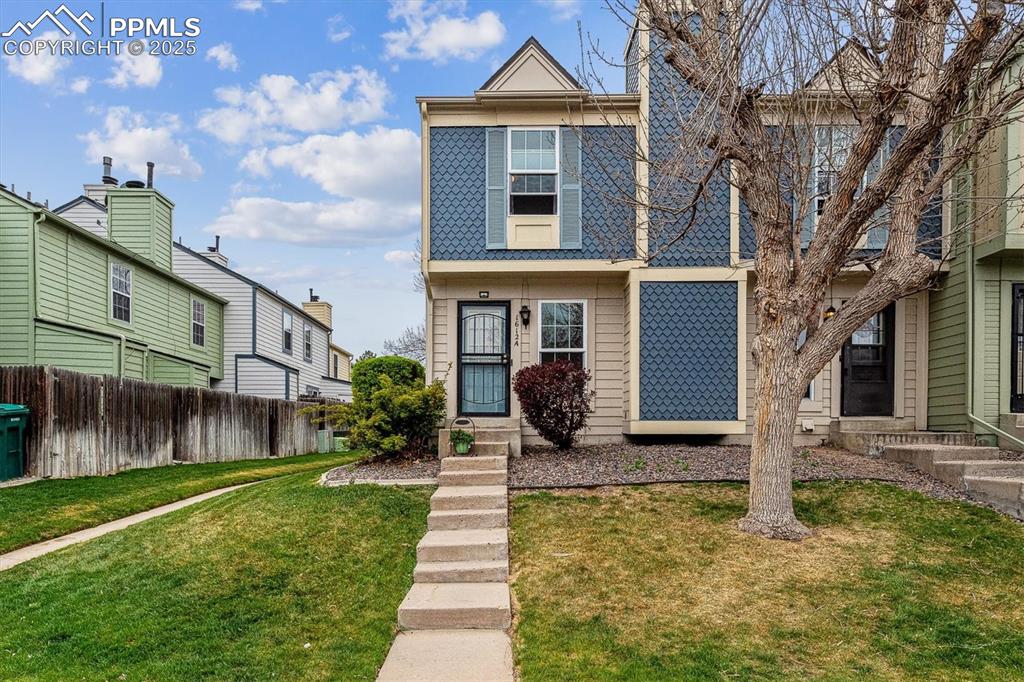 Image 2 of 24: View of front facade featuring a front lawn, fence, and entry steps