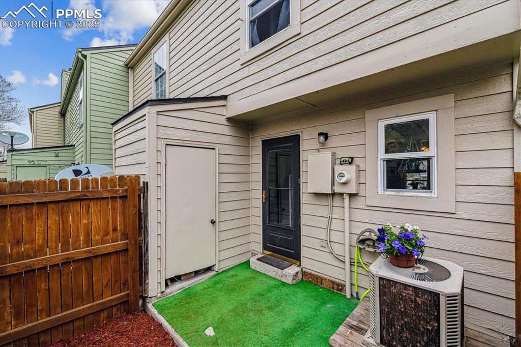 Image 22 of 24: View of exterior entry with central air condition unit and fence