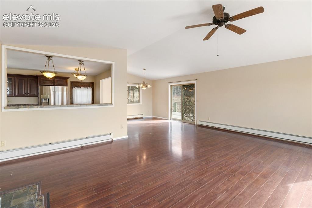 Image 15 of 40: Expansive open-concept living area featuring wood-finish flooring, a ceilin