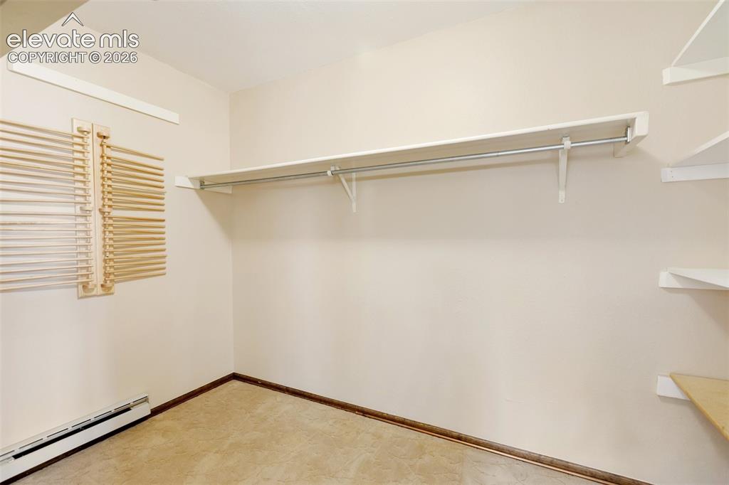 Image 25 of 40: Built-in closet shelving, integrated hanging rod, and wall-mounted wooden b