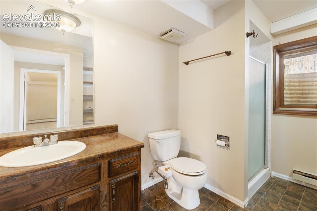 Image 29 of 40: Dark wood-finish vanity with an oval sink and brown countertop