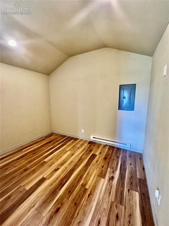 Image 34 of 40: Vaulted ceiling with recessed lighting, wood-finish flooring, and white wal