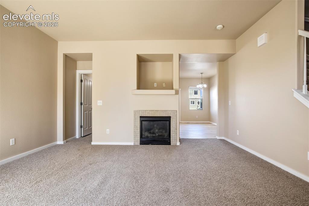 Image 10 of 34: Living Room is open to kitchen and there is a 1/2 bath hidden away from kit