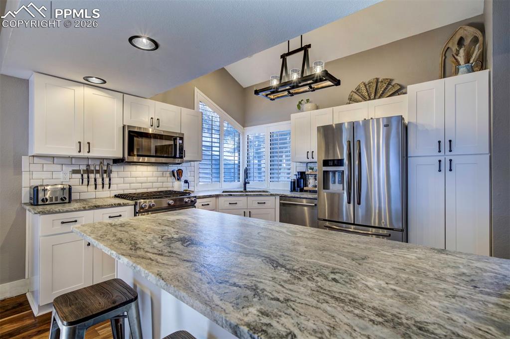 Image 17 of 29: Kitchen with appliances with stainless steel finishes, white cabinetry, and
