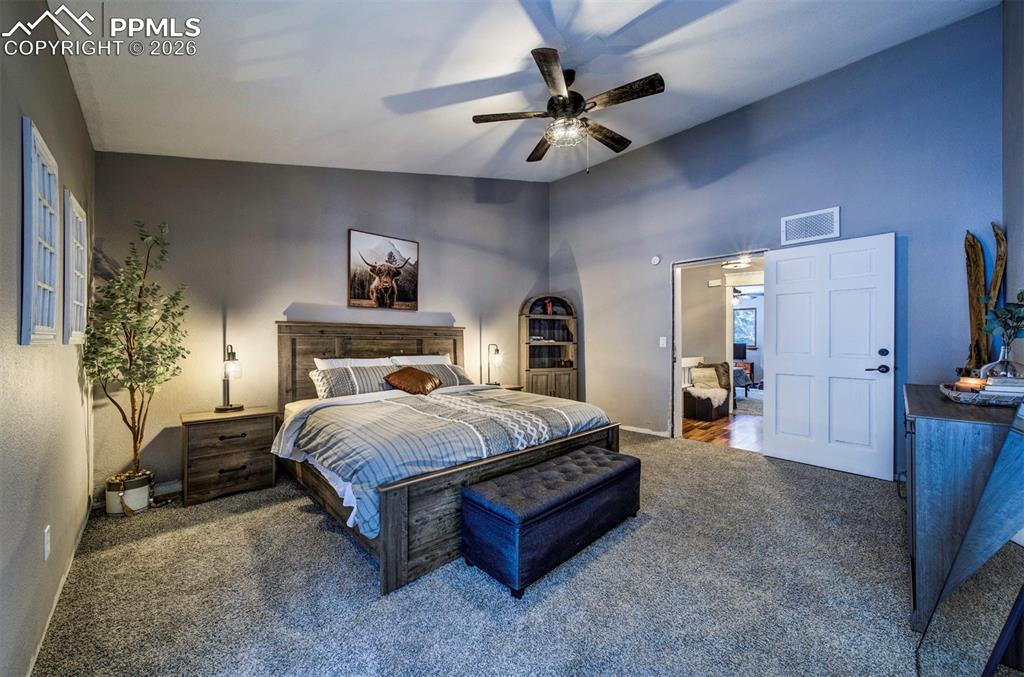 Image 18 of 29: Bedroom featuring carpet, ceiling fan, and lofted ceiling