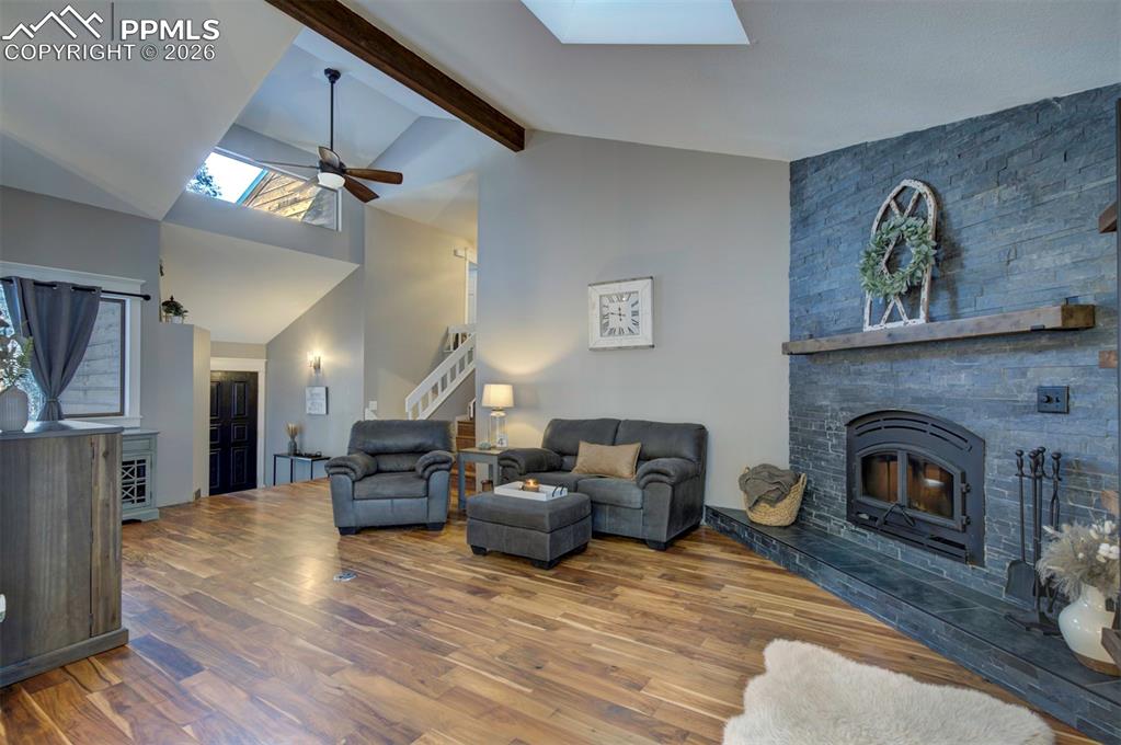 Image 8 of 29: Living room featuring a skylight, beamed ceiling, a ceiling fan, high vault