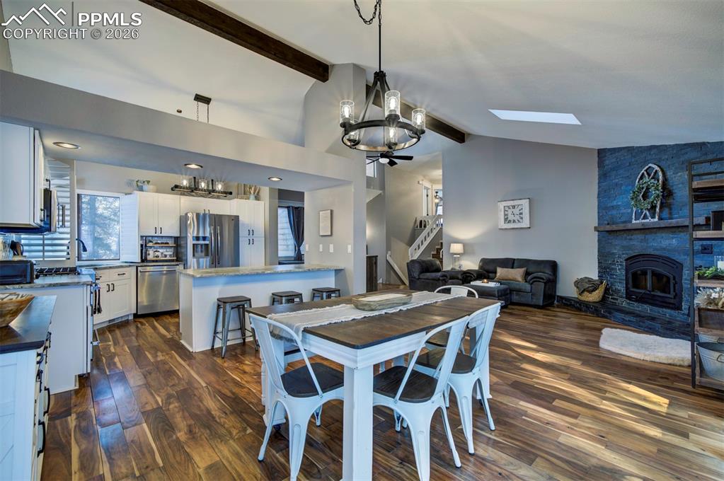 Image 9 of 29: Dining space featuring a chandelier, dark wood finished floors, beamed ceil