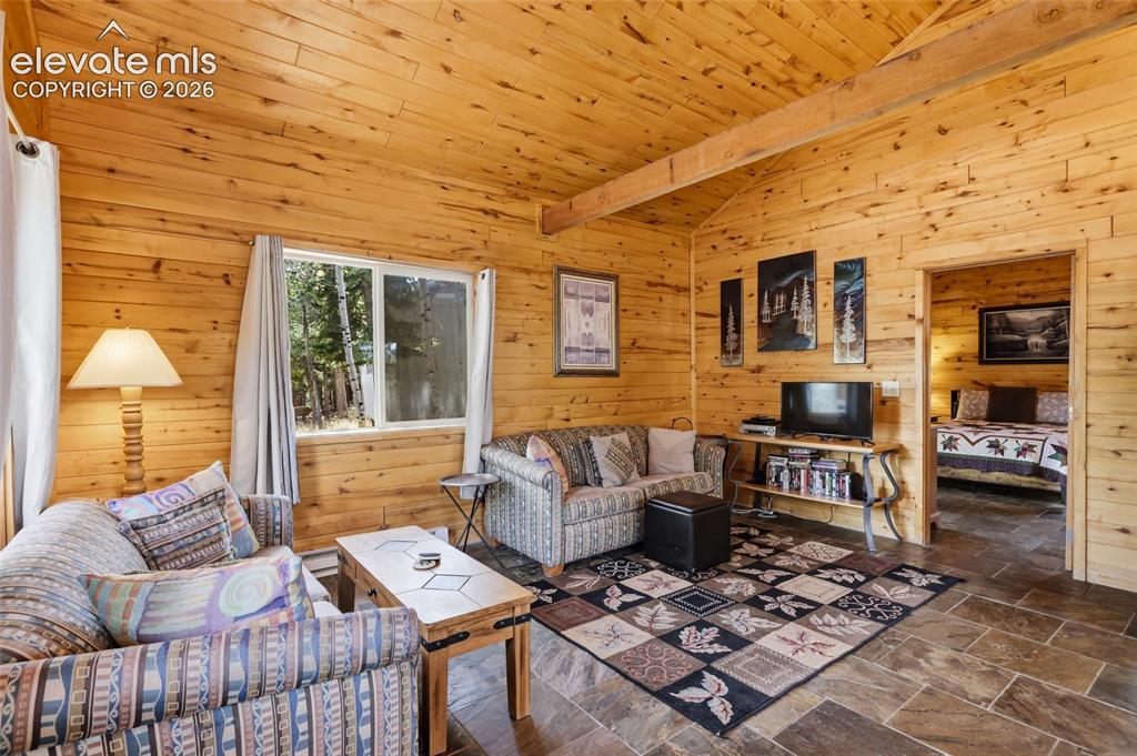 Image 12 of 28: Kitchen featuring wood-paneled walls, vaulted wood-plank ceilings with rece