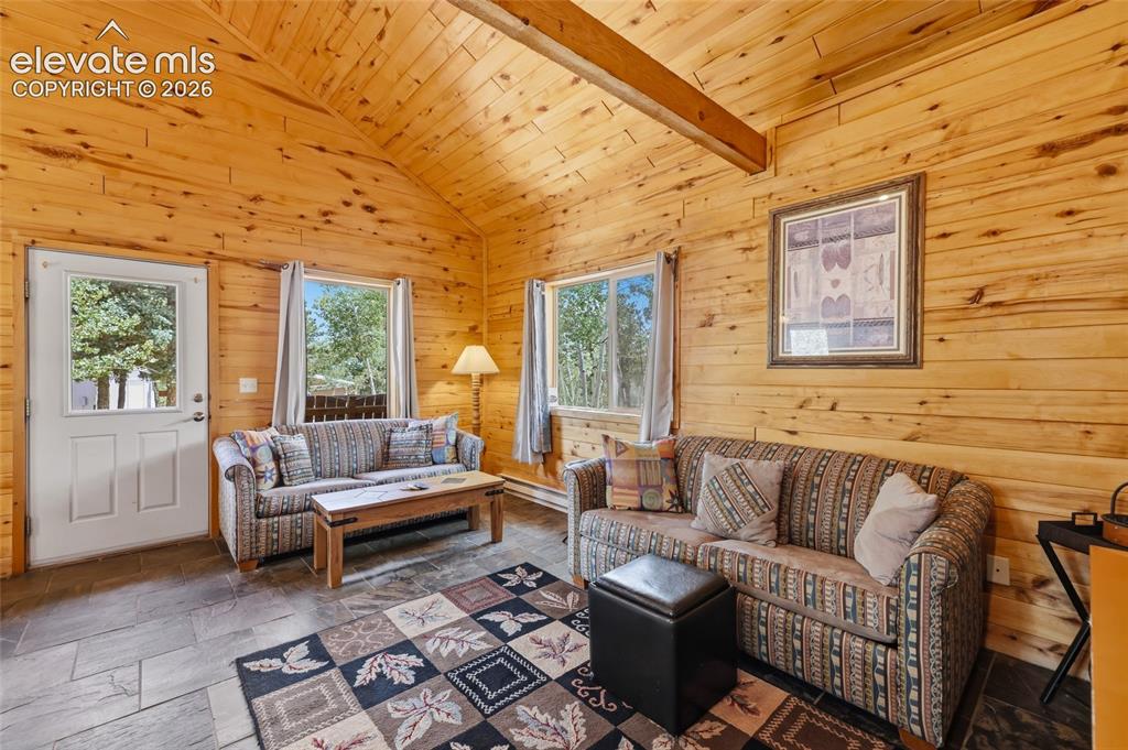 Image 13 of 28: Wood-paneled room featuring a sloped ceiling with a ceiling fan, two window