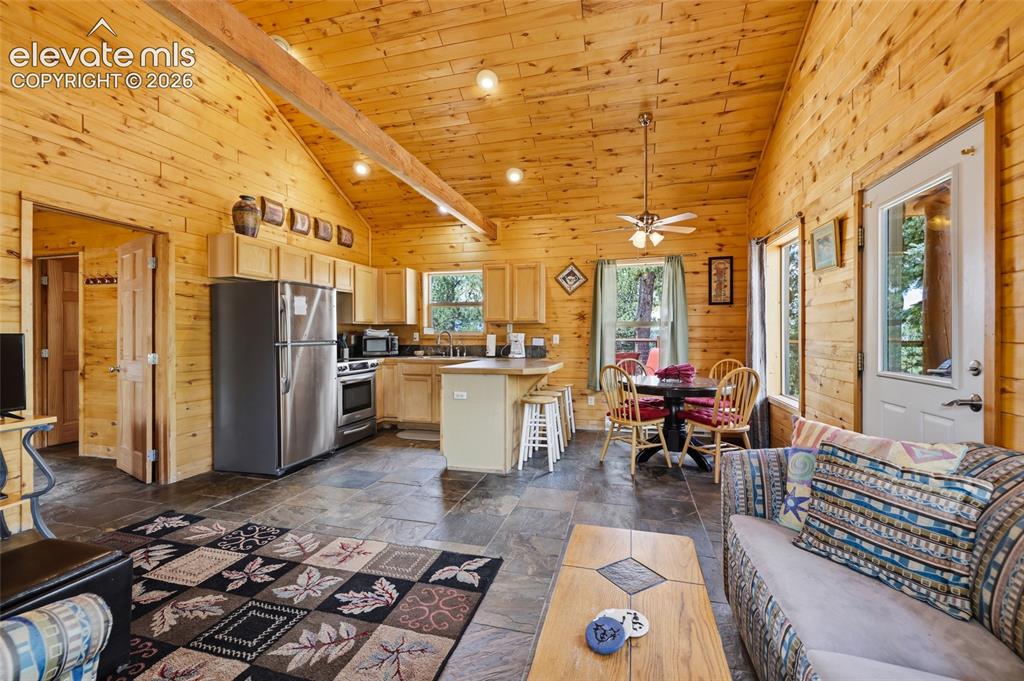 Image 15 of 28: Kitchen featuring wood plank walls, a vaulted wood plank ceiling with expos