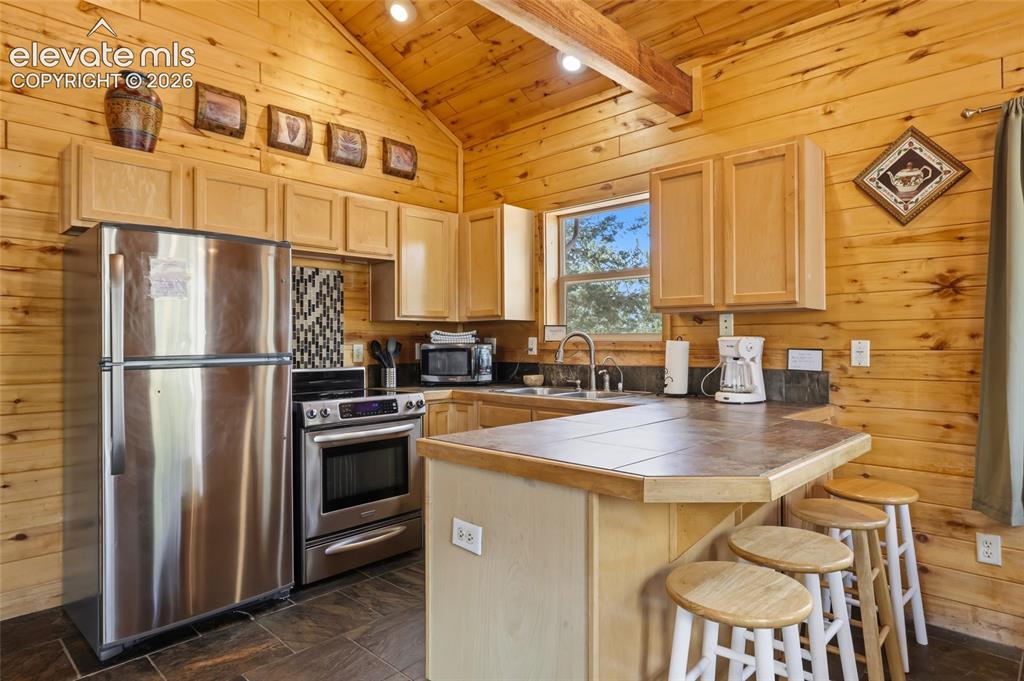 Image 19 of 28: Vaulted ceiling with wood paneling, complementing the wood-paneled walls