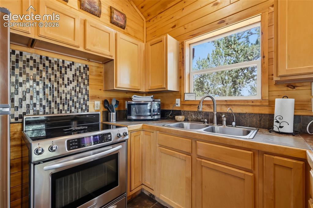 Image 20 of 28: Room featuring extensive wood paneling on walls and vaulted ceiling, durabl