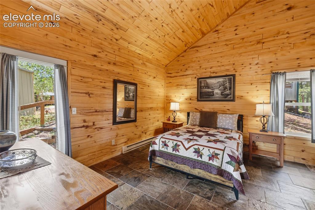 Image 21 of 28: Bathroom featuring wood-paneled walls and ceiling, a pedestal sink with ove