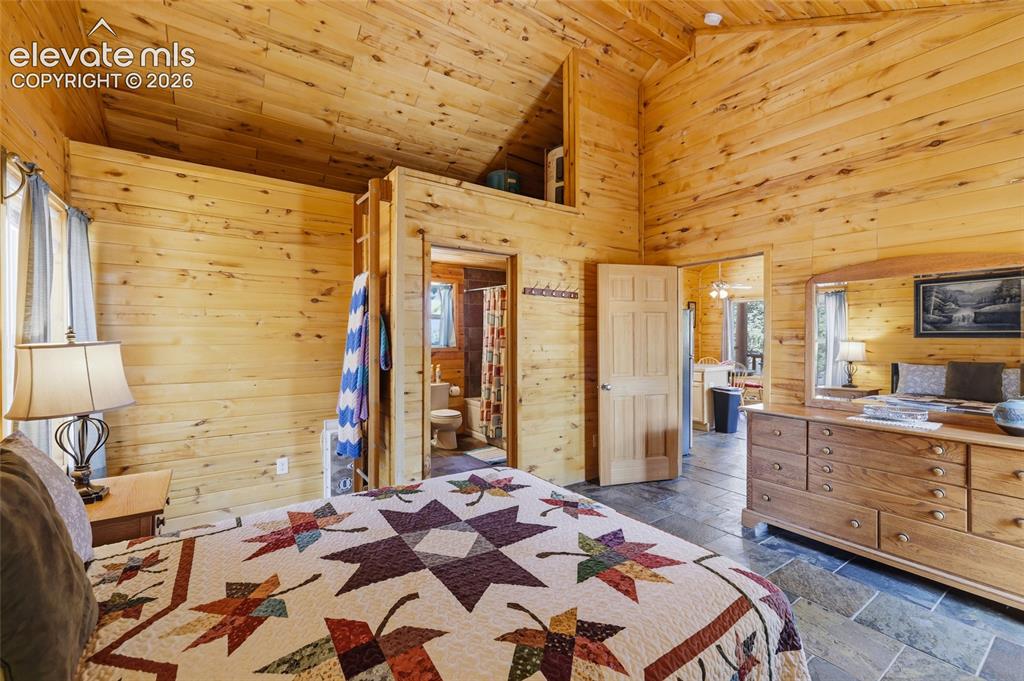 Image 22 of 28: Utility area with wood plank walls and coordinating wood plank ceiling