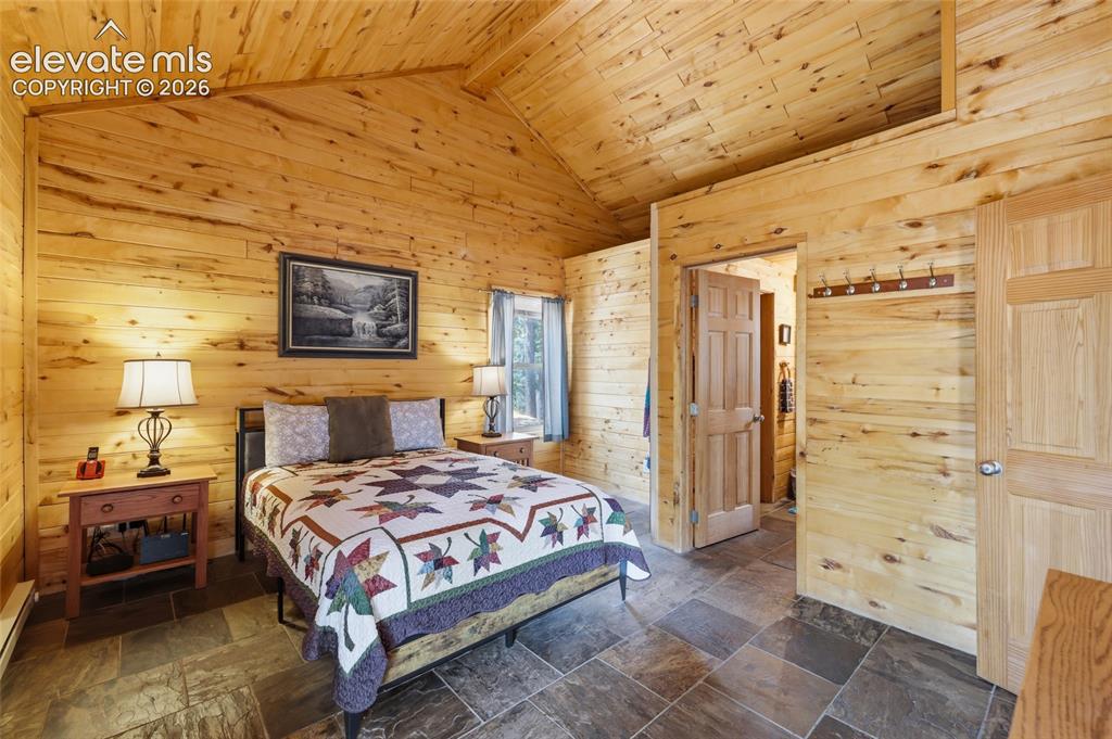 Image 24 of 28: Mountain property featuring a log cabin structure with a blue metal roof, s