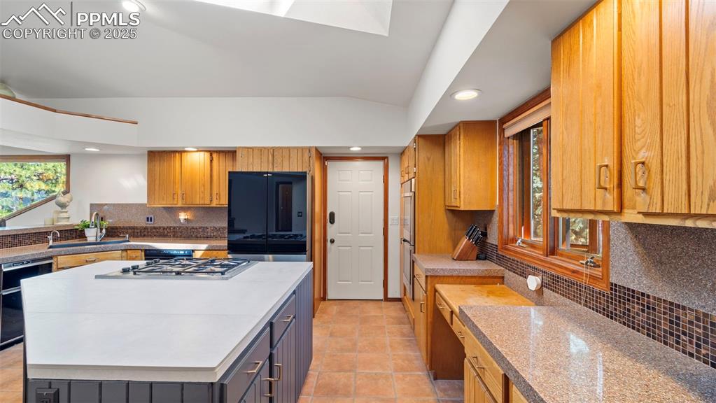 Image 14 of 46: Kitchen with backsplash, healthy amount of natural light, light countertops