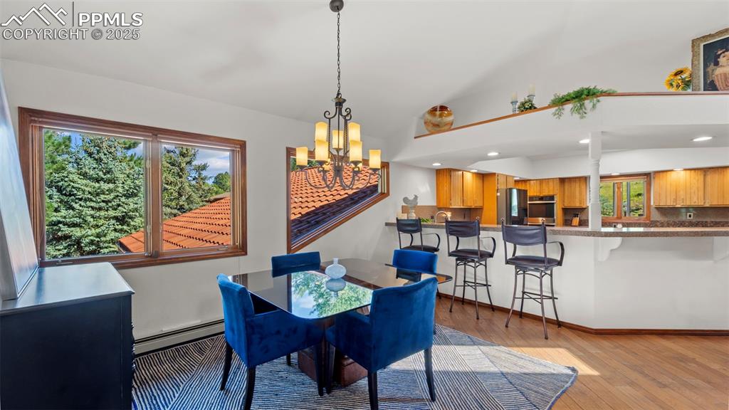 Image 16 of 46: Dining area featuring a chandelier, light wood-type flooring, baseboard hea
