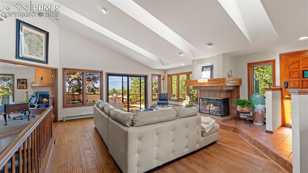 Image 17 of 46: The great room boast vaulted ceilings, skylights, and a wall of windows fra