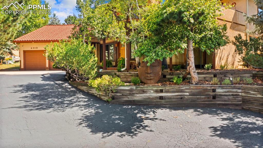Image 2 of 46: View of front of property featuring asphalt driveway, a tile roof, an attac