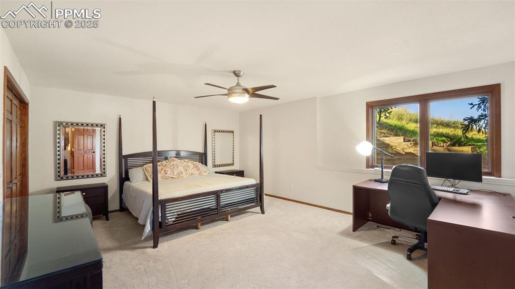 Image 34 of 46: This first-floor primary suite offers serene views of nature, large enough 