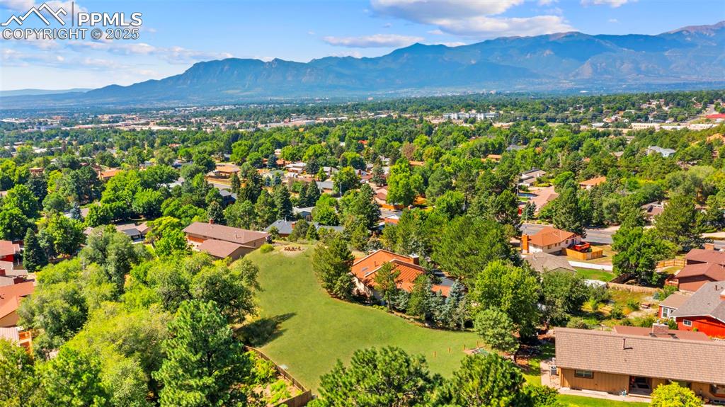 Image 40 of 46: Aerial view of residential area featuring a mountainous background