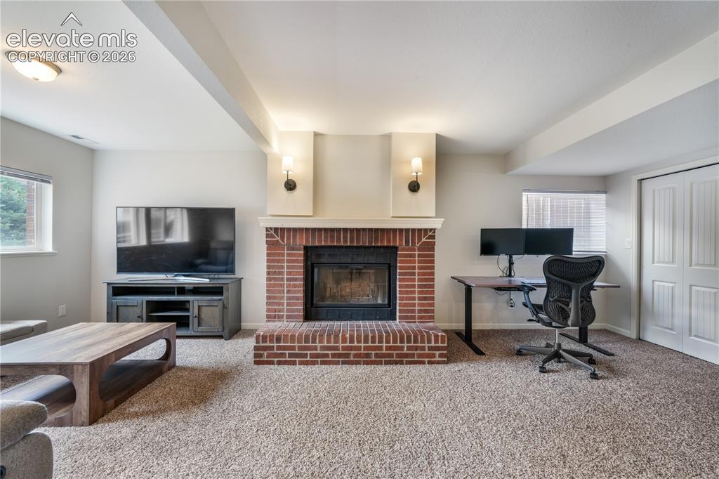 Image 25 of 50: Lower Level Living Room with Wood-Burning Fireplacel