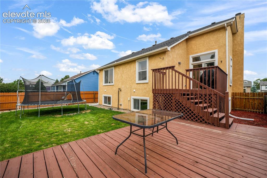 Image 41 of 50: Back of Home with Built in Lower Back Patio