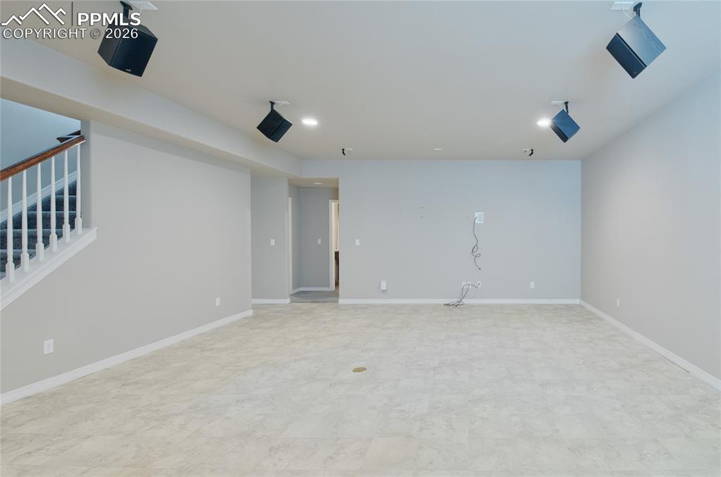 Image 25 of 36: Spacious room featuring light-colored flooring, painted walls, and ceiling-