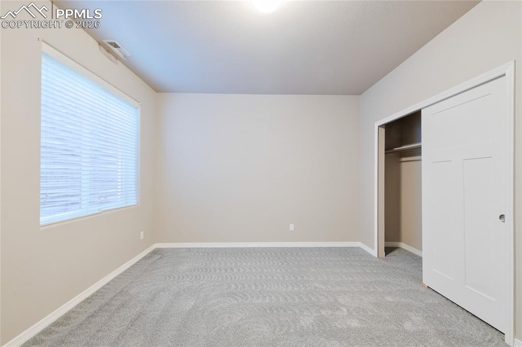 Image 26 of 36: This room features a window with horizontal blinds, neutral-toned walls, an