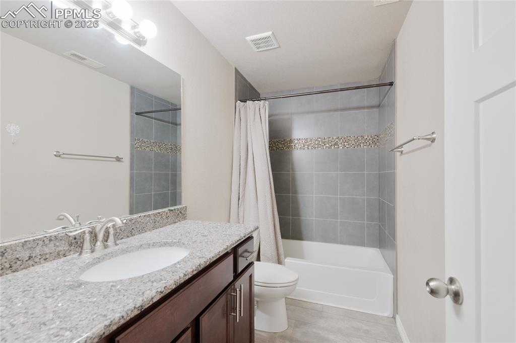 Image 27 of 36: Bathroom featuring a vanity with a granite countertop, a built-in sink, and