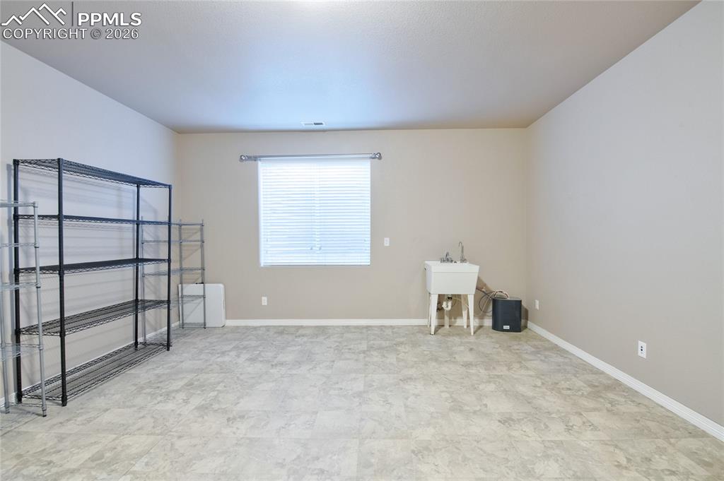 Image 30 of 36: The property features a utility room with a window, a utility sink, and dur
