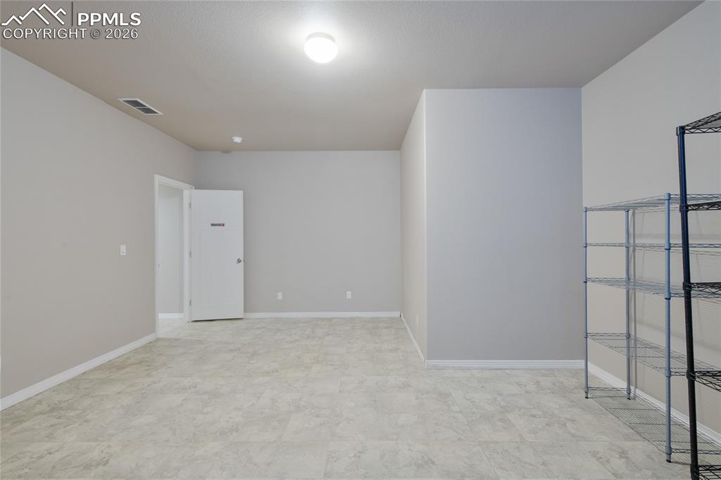 Image 31 of 36: Spacious room featuring light-colored flooring, neutral wall tones, and an 