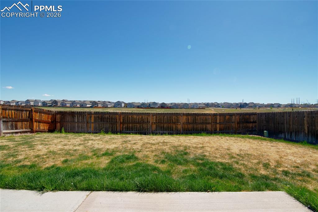 Image 34 of 36: The property features a fenced yard with a concrete patio area and an expan