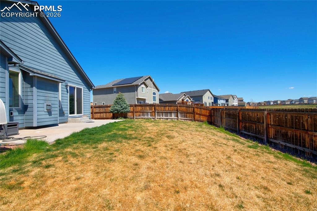 Image 35 of 36: The property features a private yard with a wooden fence and a concrete pat
