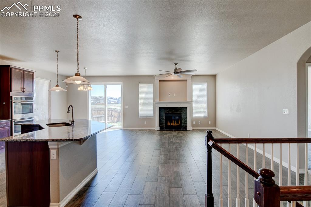 Image 5 of 36: Spacious open concept living area featuring wood-look tile flooring, a fire