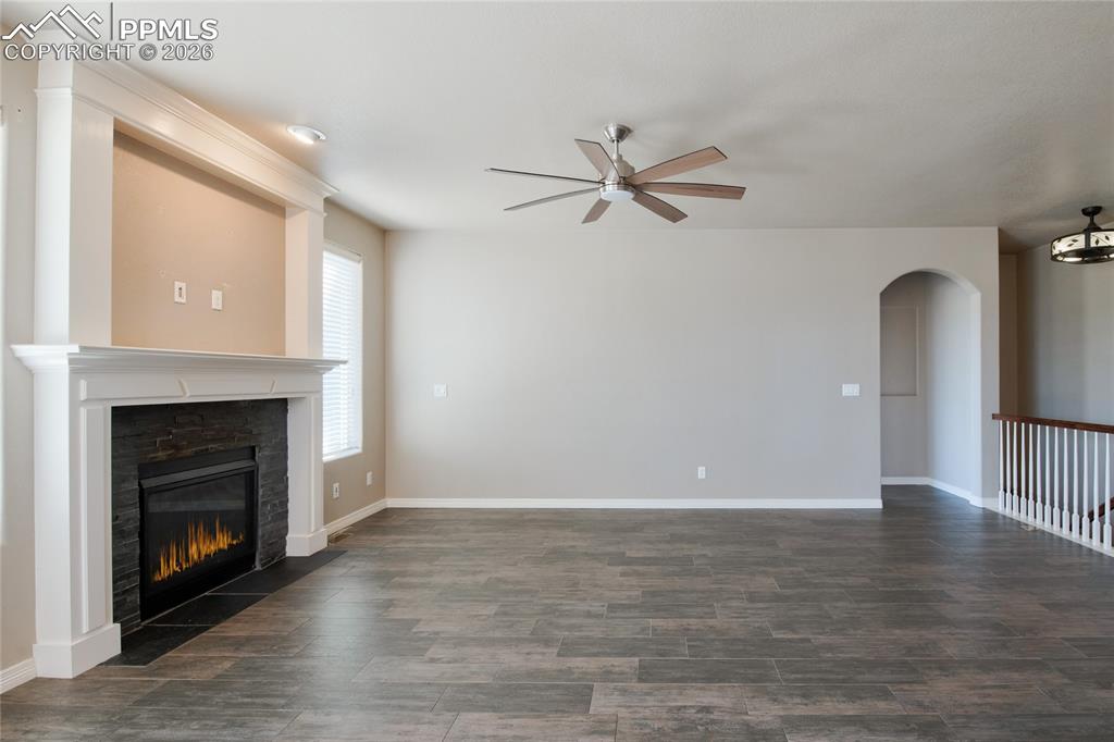 Image 7 of 36: Living area featuring a fireplace with a white mantel and black stone surro