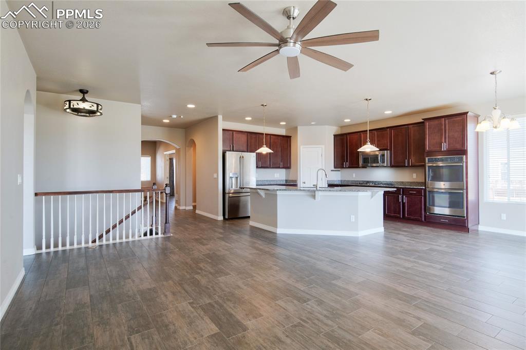 Image 8 of 36: Spacious open-concept living area featuring wood-look flooring, a kitchen i