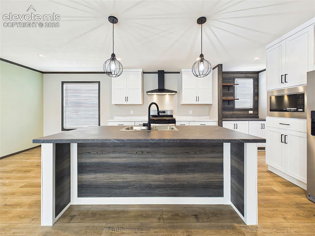 Image 17 of 50: Kitchen – Expansive island anchors the kitchen with generous prep space, st