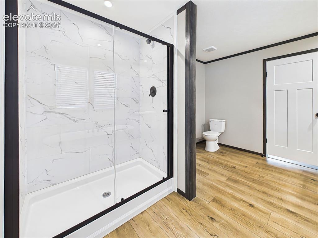 Image 32 of 50: Primary Bathroom – Elegant glass-enclosed shower with marble-look tile surr