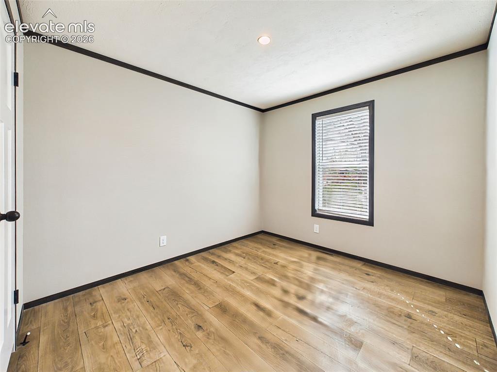 Image 39 of 50: Bedroom 2 – Bright secondary bedroom with a large window, neutral finishes,